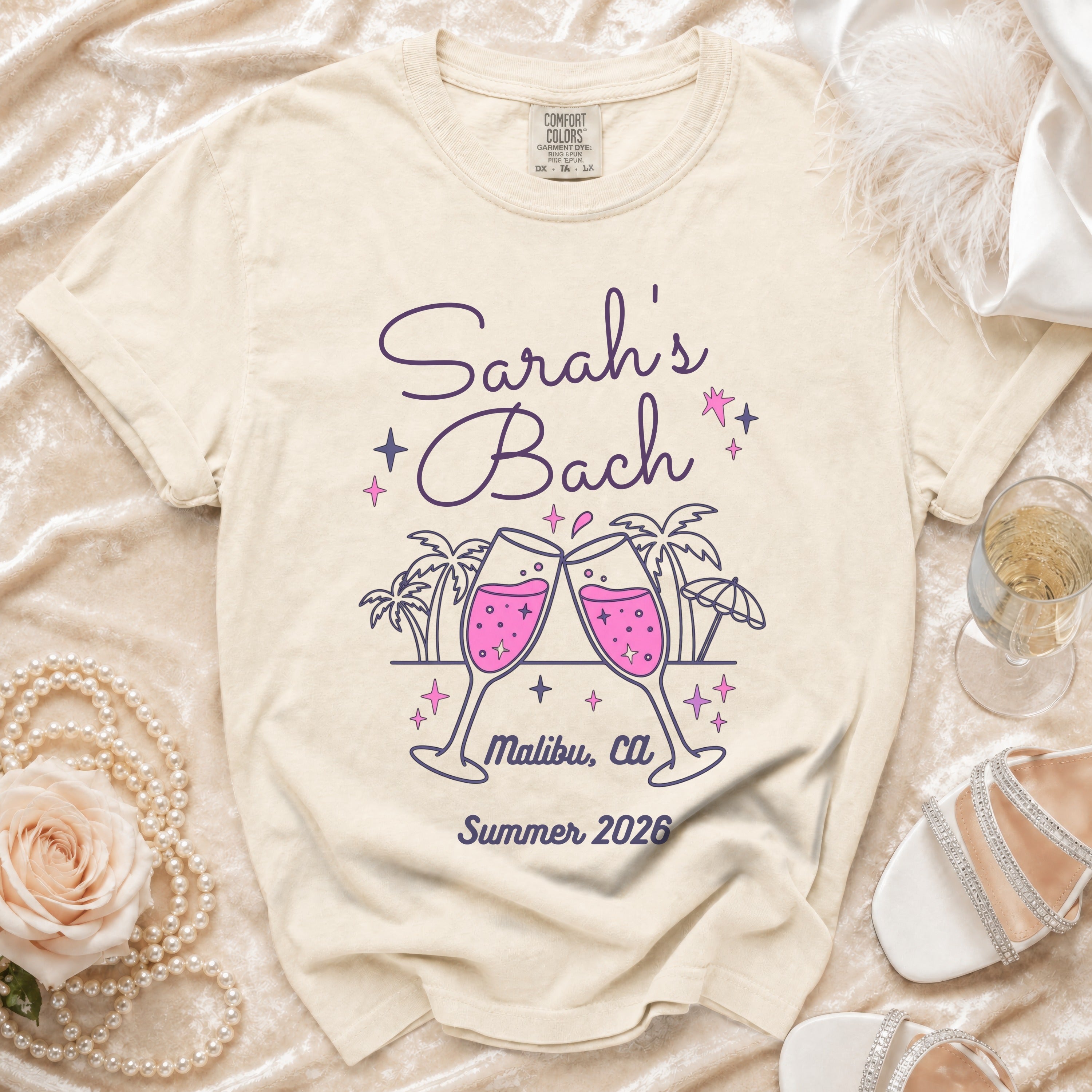 Cream t-shirt with "Sarah's Bach Malibu, Ca Summer 2026" and champagne glasses.