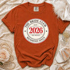 Orange t-shirt with "The Bride Club Est. 2026 Members Only" graphic.