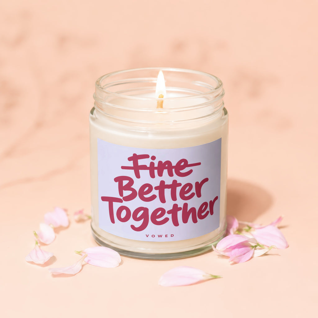 Candle with "Fine Better Together" text and pink flower petals on a peach background.