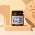 Amber jar candle with "A White Dress and 400 Opinions" label, "vowed" at bottom.
