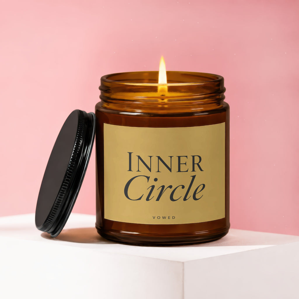 Amber jar candle with lit flame and black lid, labeled "Inner Circle"