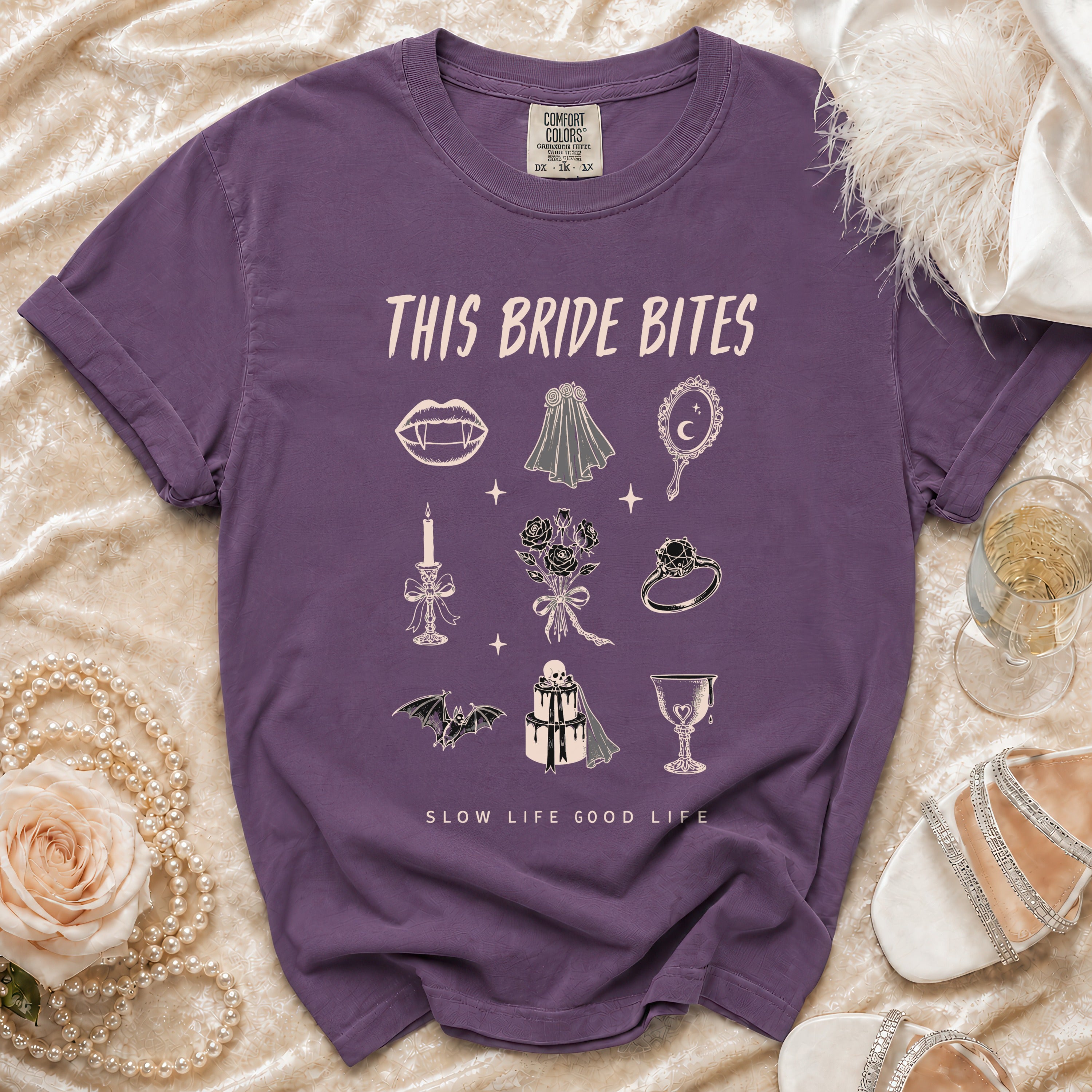 Purple t-shirt with "This Bride Bites" and gothic wedding illustrations.
