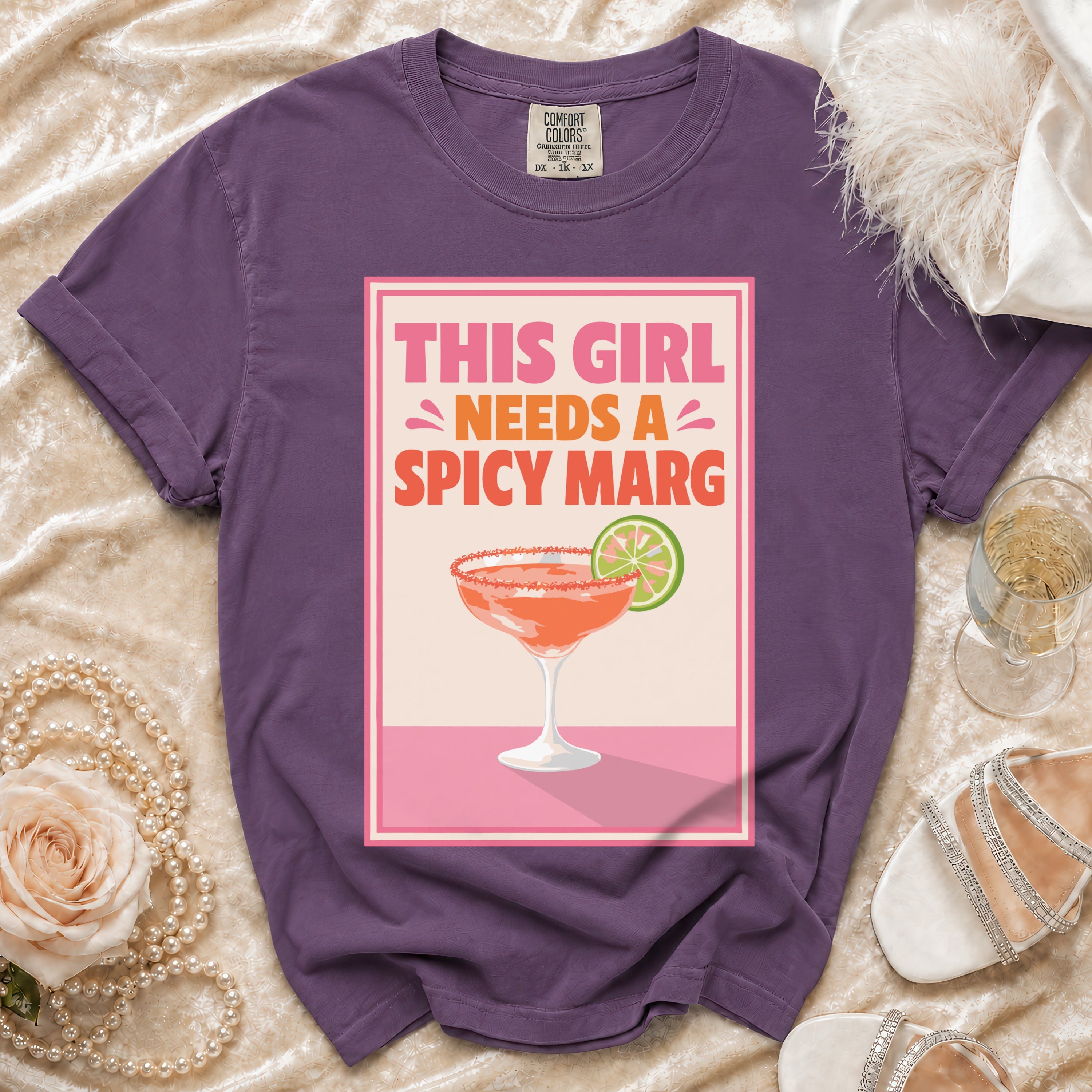 Purple t-shirt with "This Girl Needs a Spicy Marg" text graphic and margarita illustration.