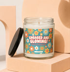 Candle with label saying "ENGAGED AND GLOWING! WITH ALL THE SPARKLE" on floral background.