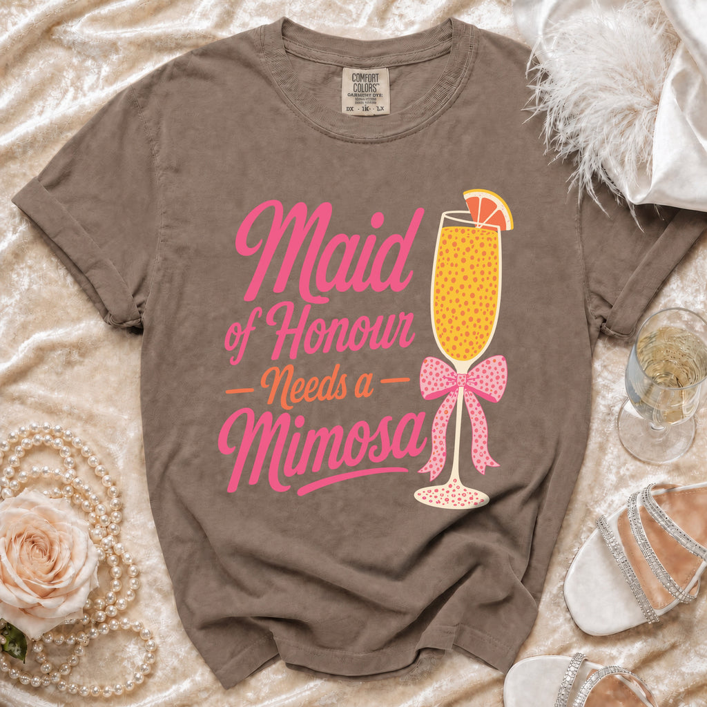Brown t-shirt with pink text "Maid of Honour Needs a Mimosa" and a mimosa graphic.