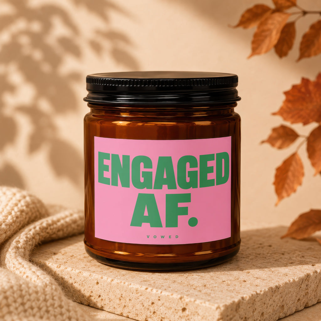 Amber jar candle with pink label reading "ENGAGED AF." and "vowed".