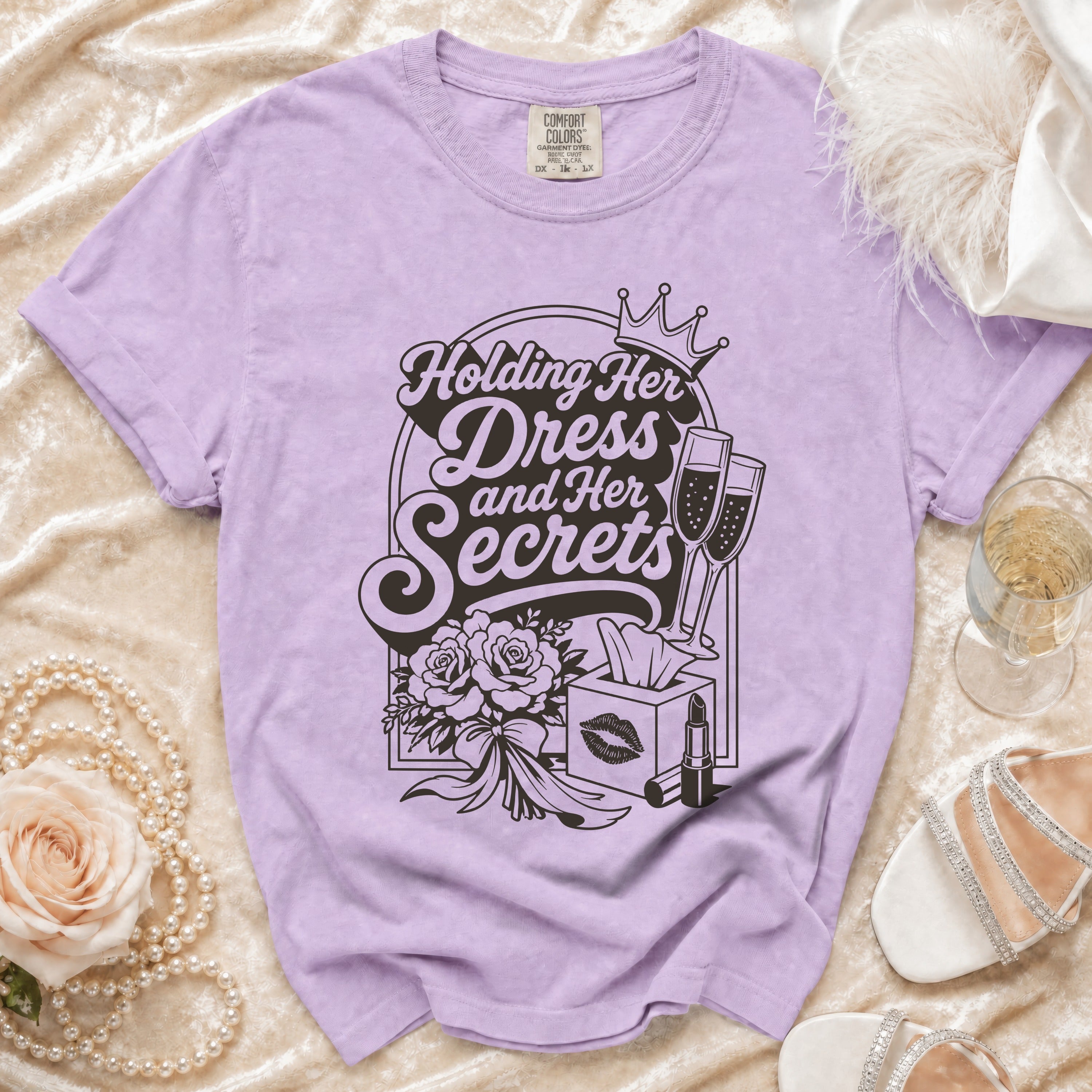 Lavender t-shirt with "Holding Her Dress and Her Secrets" text and graphics.