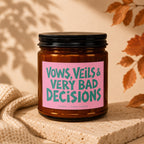 Amber candle with pink label reading "Vows, Veils & Very Bad Decisions".