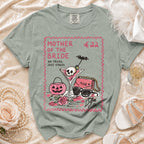 Green t-shirt with "Mother of the Bride" text, a cocktail, and accessories.