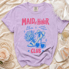 Purple t-shirt with "Maid of Honor Club" text and graphics of a shoe, flowers, and sunglasses.