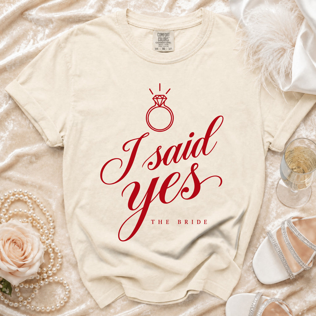 Cream t-shirt with red "I said yes THE BRIDE" text and diamond ring graphic.