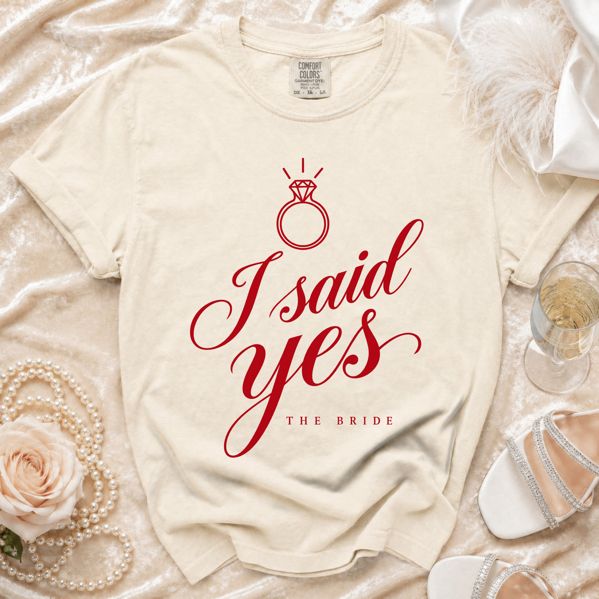 Cream t-shirt with red "I said yes THE BRIDE" text and diamond ring graphic.