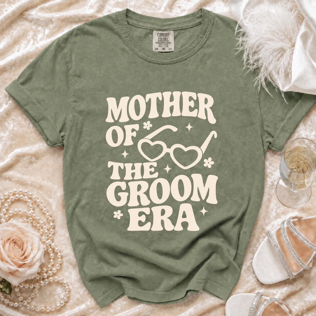 Green t-shirt with "Mother of the Groom Era" text and heart glasses graphic.