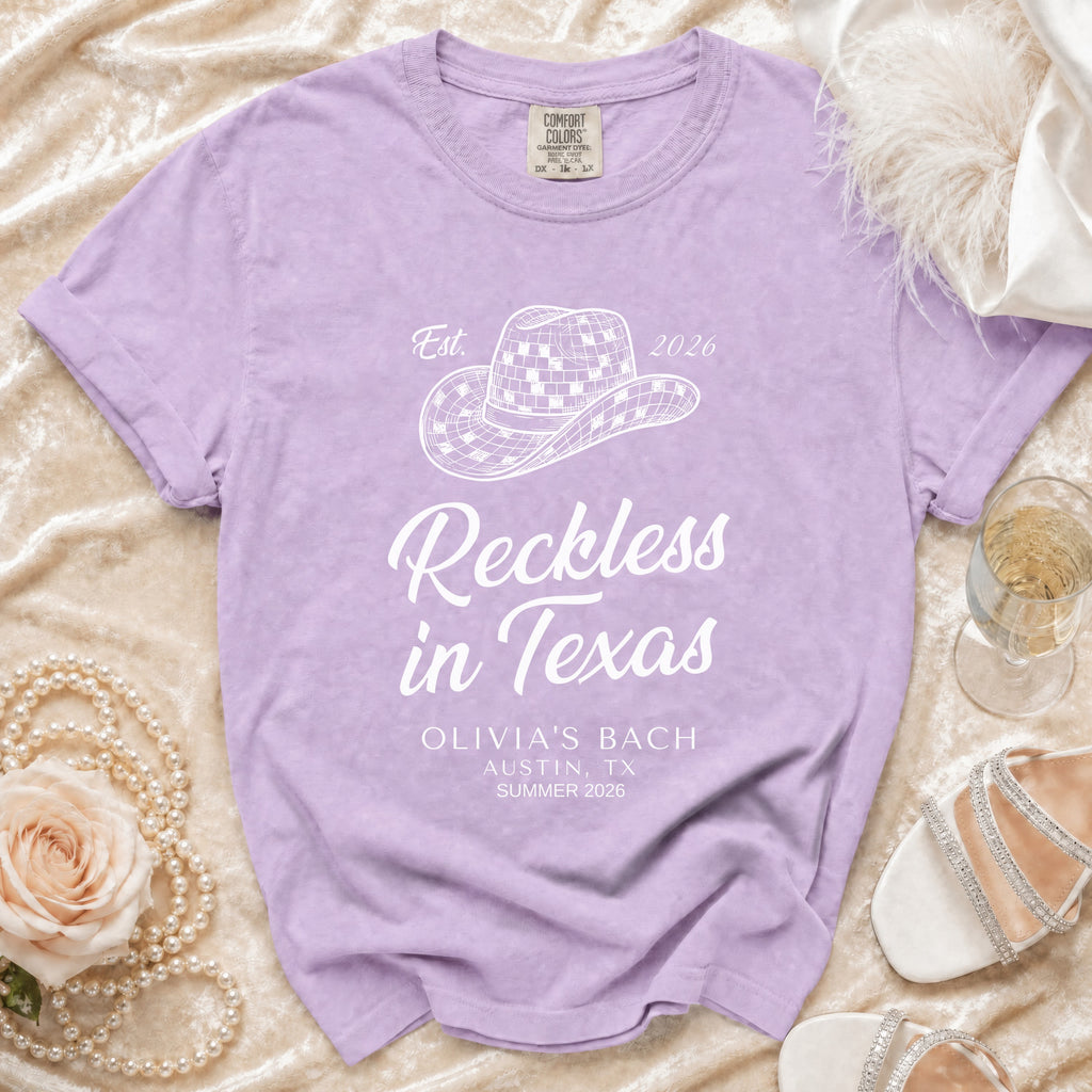 Purple t-shirt with "Reckless in Texas" and "Olivia's Bach Austin, TX Summer 2026" text.