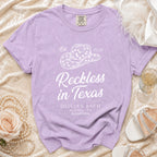 Purple t-shirt with "Reckless in Texas" and "Olivia's Bach Austin, TX Summer 2026" text.