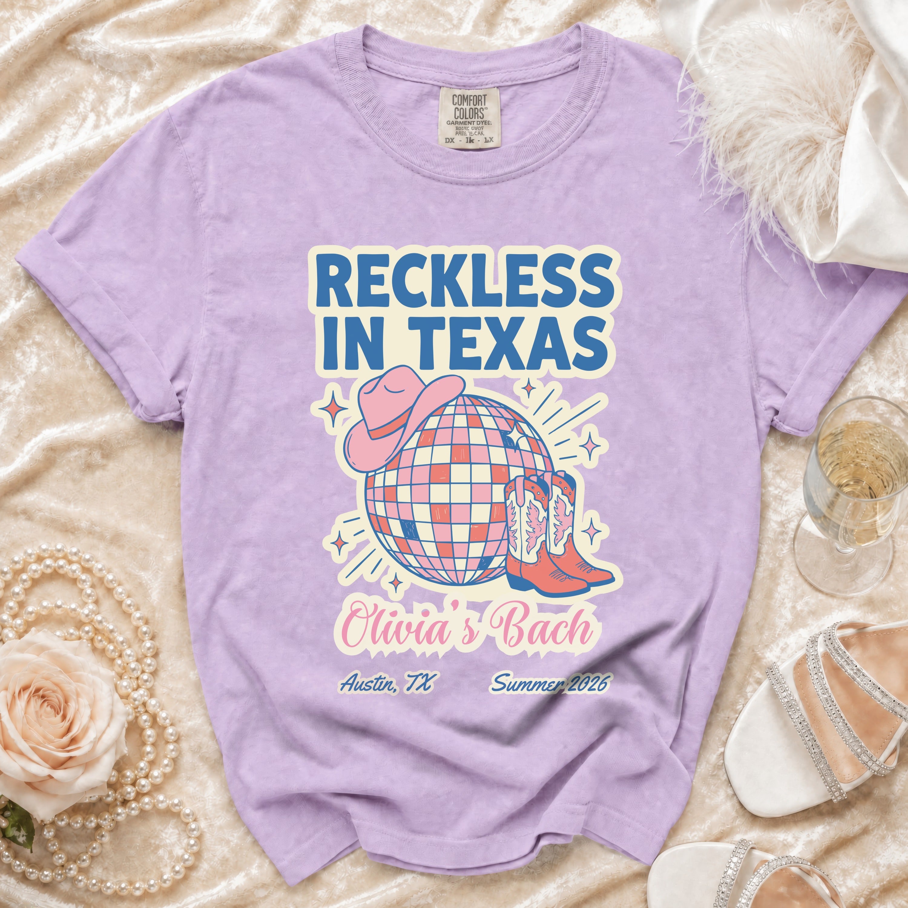 Purple t-shirt with "Reckless in Texas Olivia's Bach" and disco ball design.