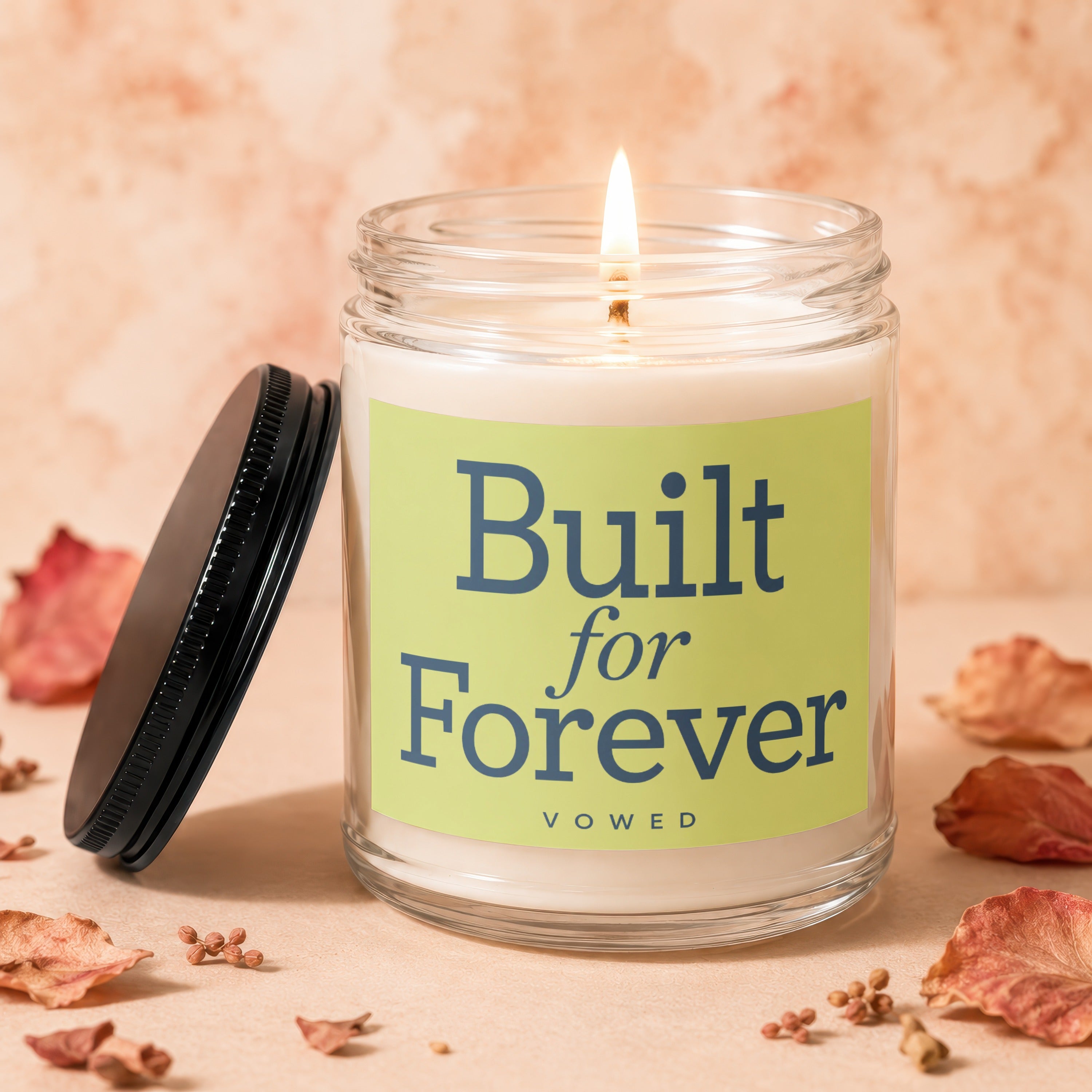 Lit candle in glass jar with light green label reading "Built for Forever vowed."