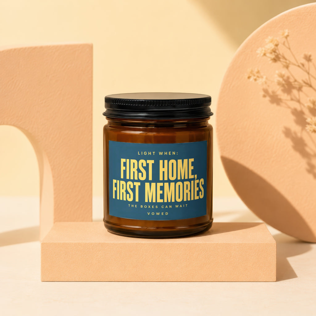 Amber candle in glass jar with blue label: "First Home, First Memories. The Boxes Can Wait. Vowed."