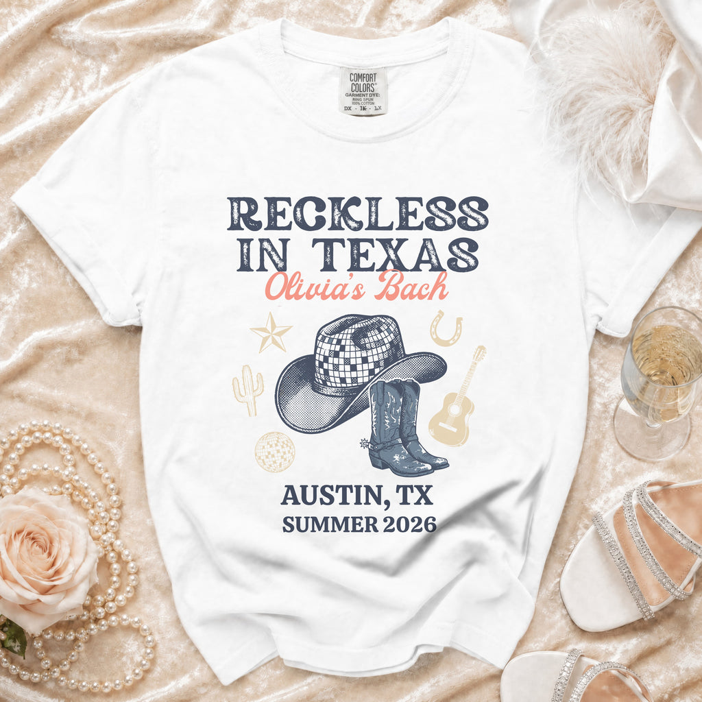 White t-shirt with "Reckless in Texas" and "Olivia's Bach" graphic.