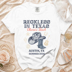 White t-shirt with "Reckless in Texas" and "Olivia's Bach" graphic.