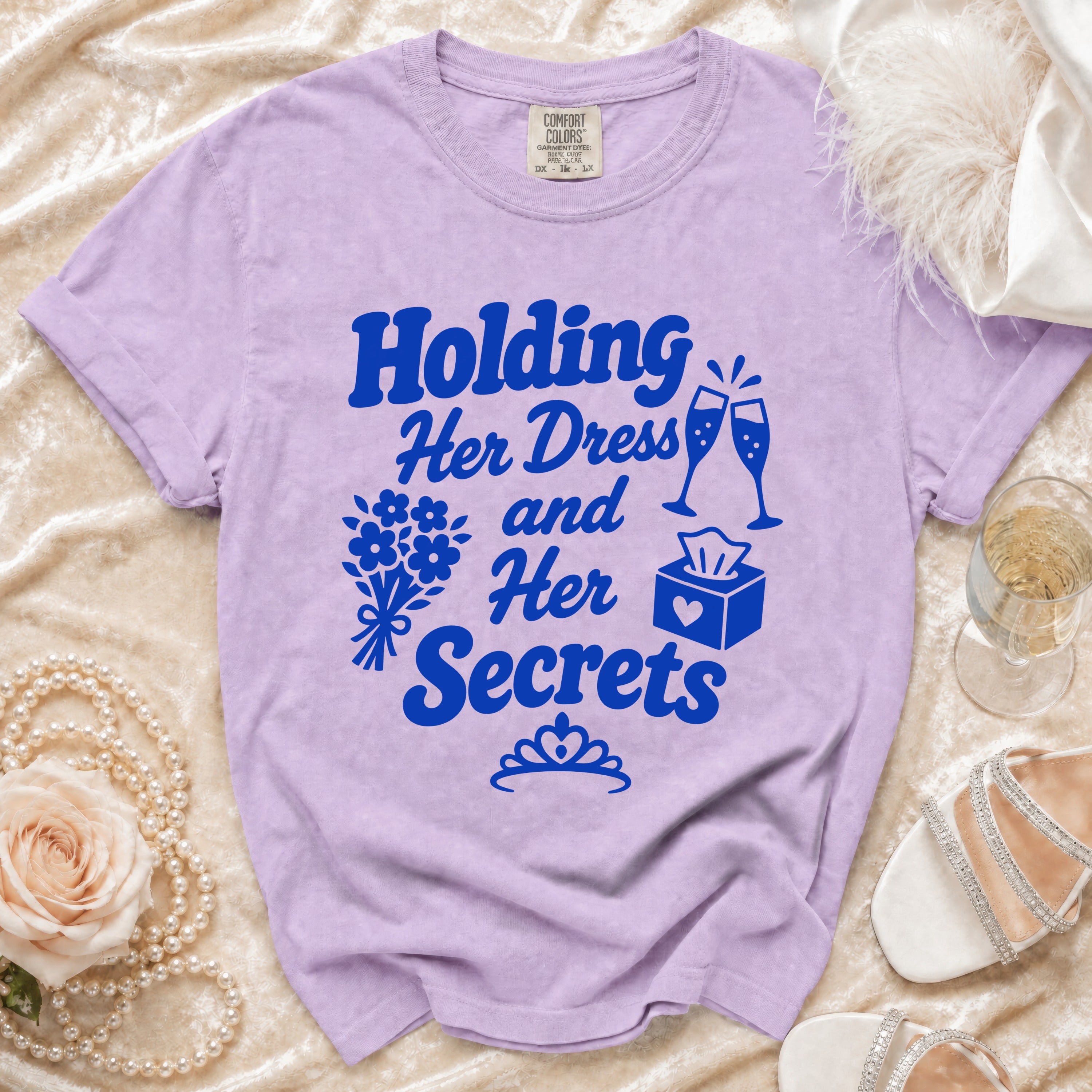 Purple t-shirt with blue text "Holding Her Dress and Her Secrets" and graphics.