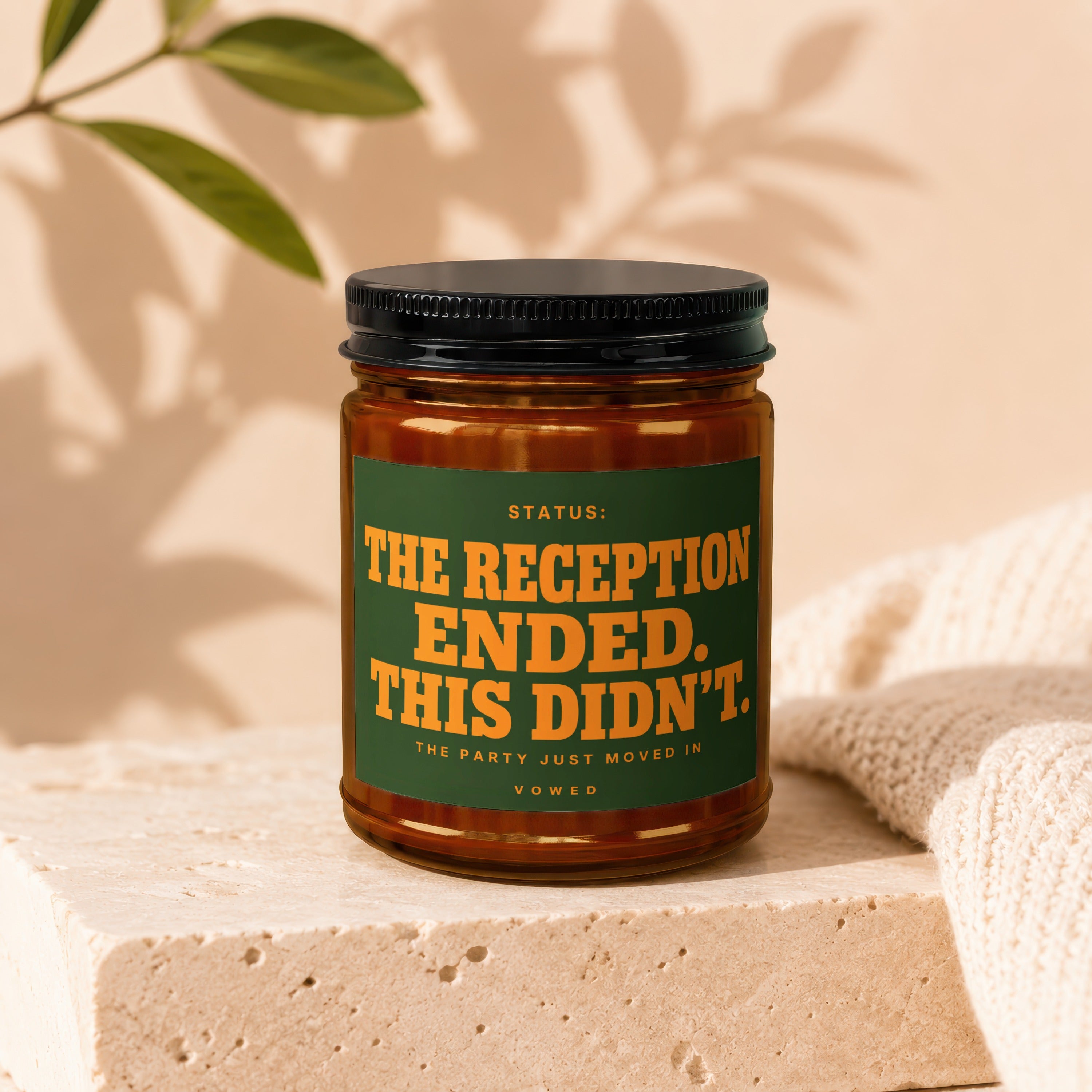 Jar candle with label: "STATUS: THE RECEPTION ENDED. THIS DIDN'T. THE PARTY JUST MOVED IN. VOWED."