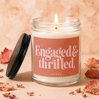 Glass candle with "Engaged & thrilled" text on a peach label.