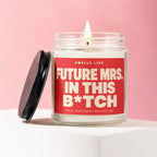 Candle with "Smells Like Future Mrs. In This B*tch" text on red label.