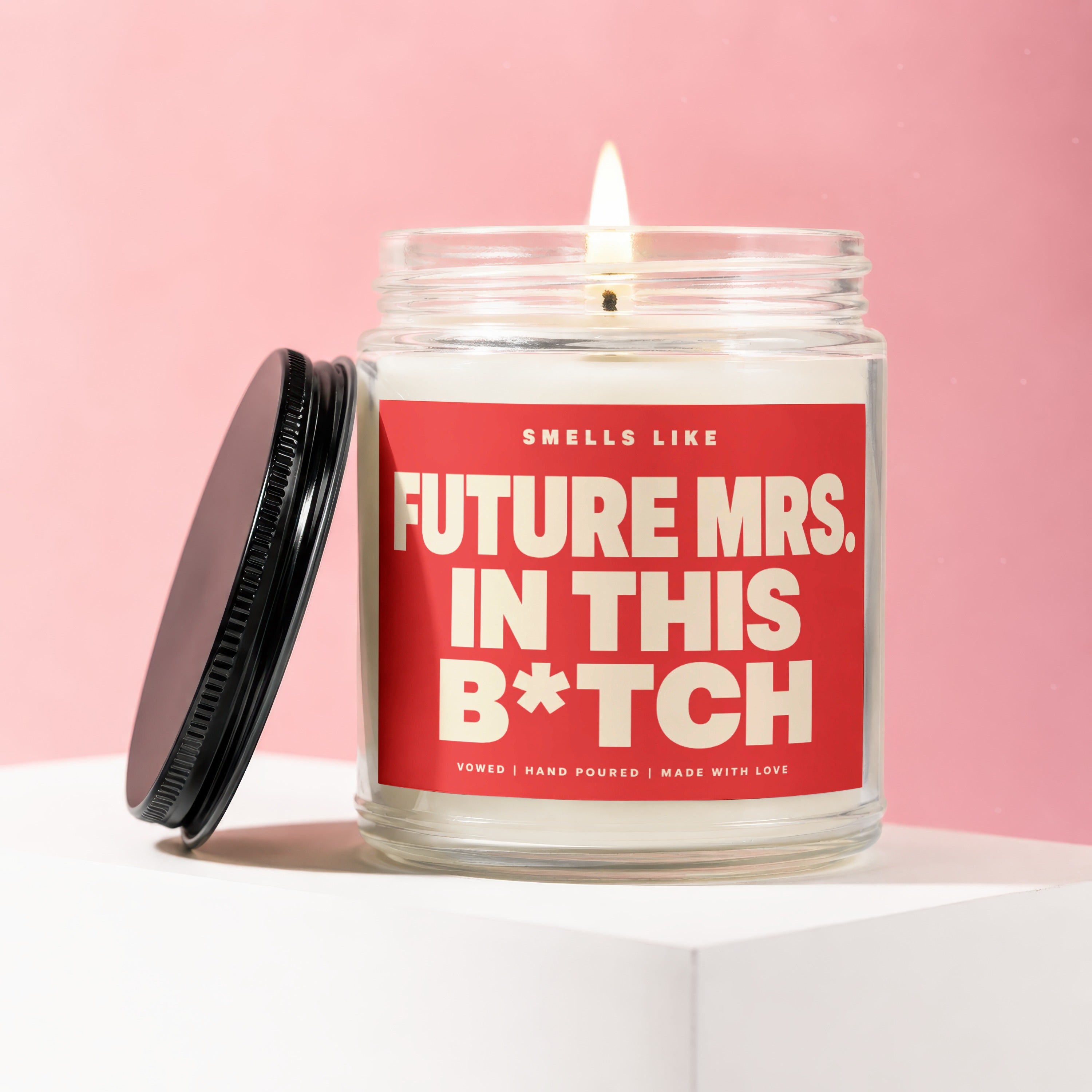 Candle with "Smells Like Future Mrs. In This B*tch" text on red label.