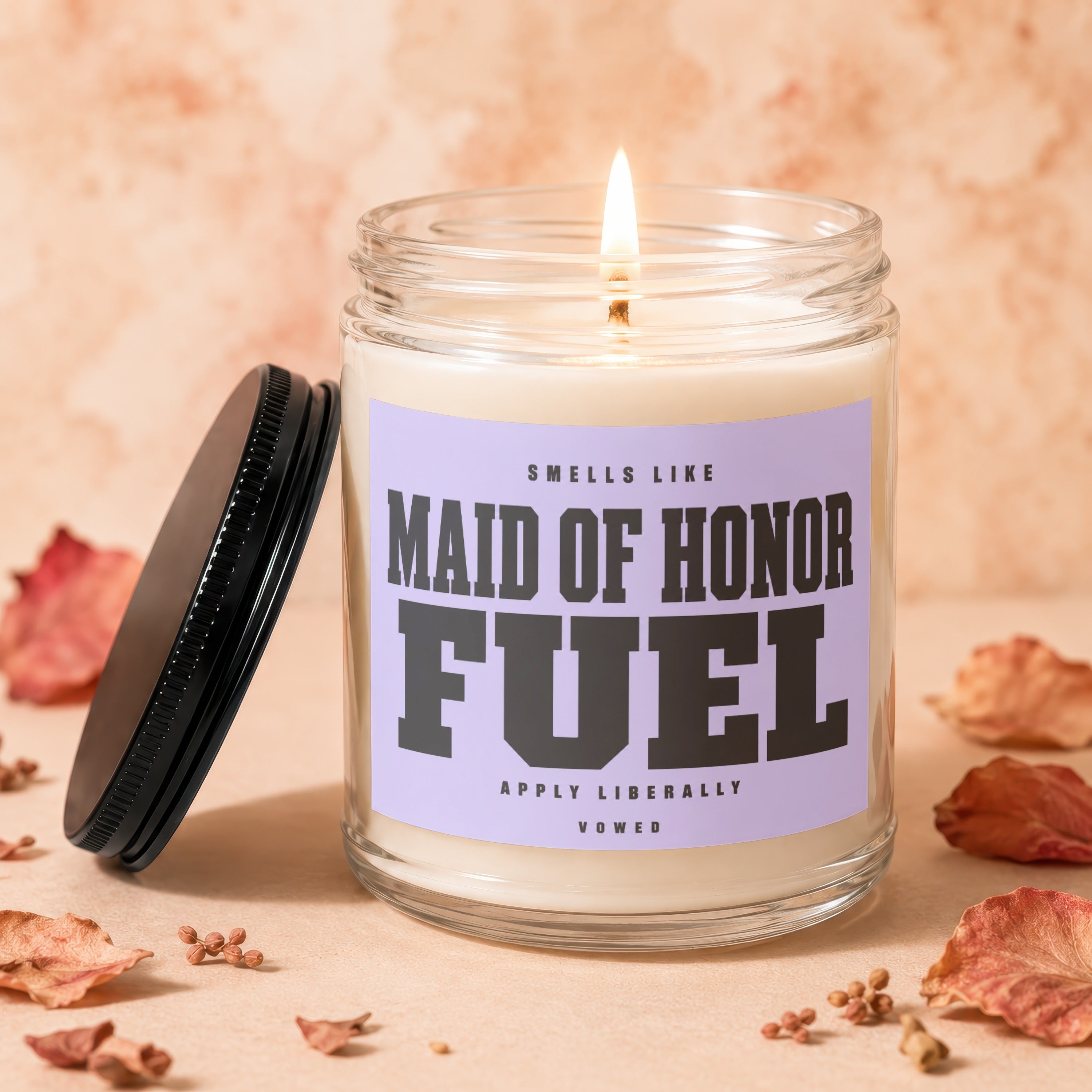Candle with "Maid of Honor Fuel" text, lid off, and lit wick.