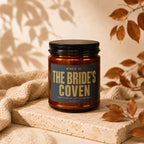 Amber jar candle with lid, labeled "The Bride's Coven Admission by Invitation Only Vowed".