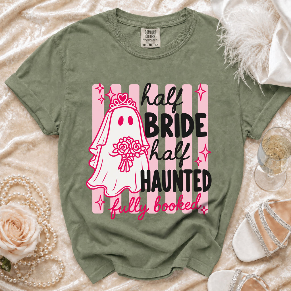 Green t-shirt with a ghost bride graphic reading "half bride, half haunted, fully booked."