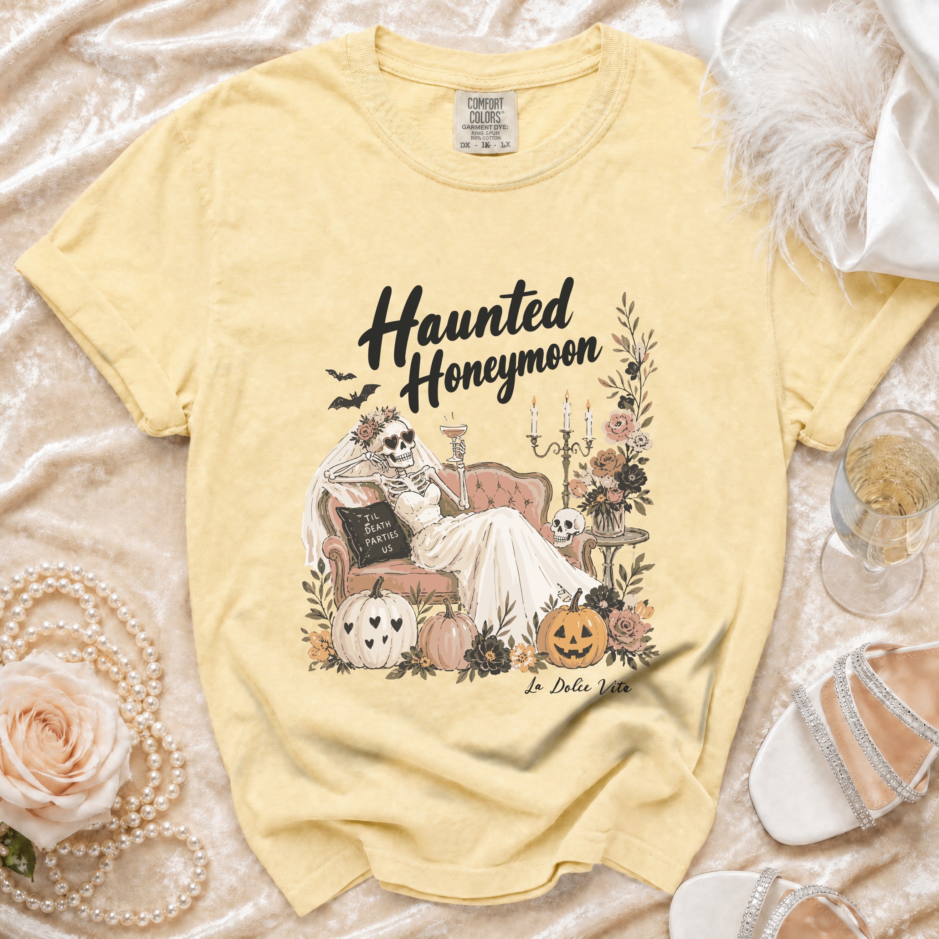 Yellow t-shirt with "Haunted Honeymoon" graphic of skeleton bride, pumpkins, and flowers.