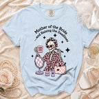 Light blue t-shirt with skeleton graphic of "Mother of the Bride" with coffee and makeup.
