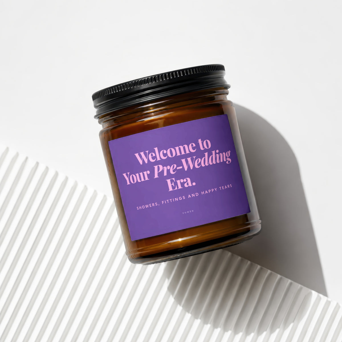 Amber glass candle with purple label saying "Welcome to Your Pre-Wedding Era."