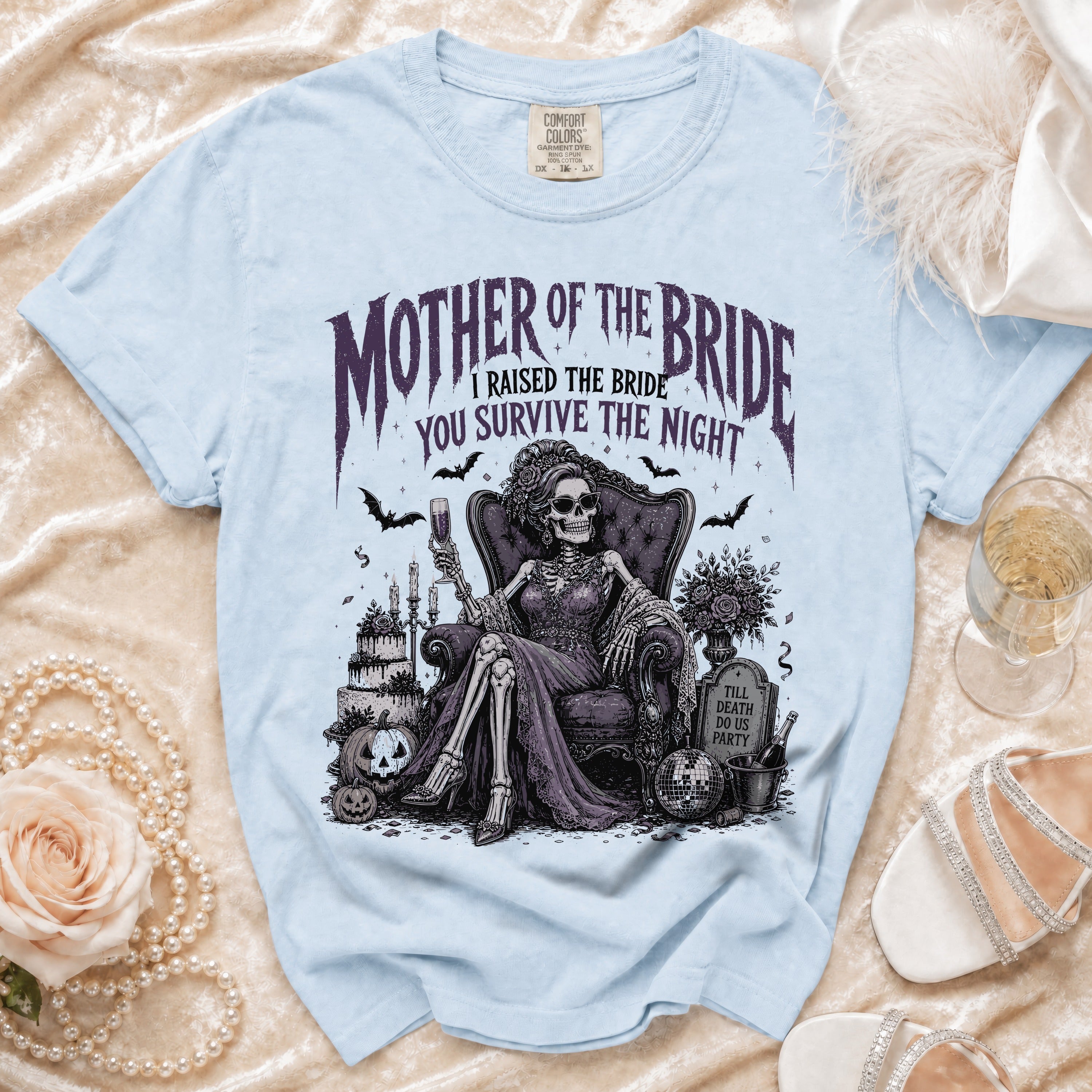 Light blue t-shirt with skeleton "Mother of the Bride" graphic and text.