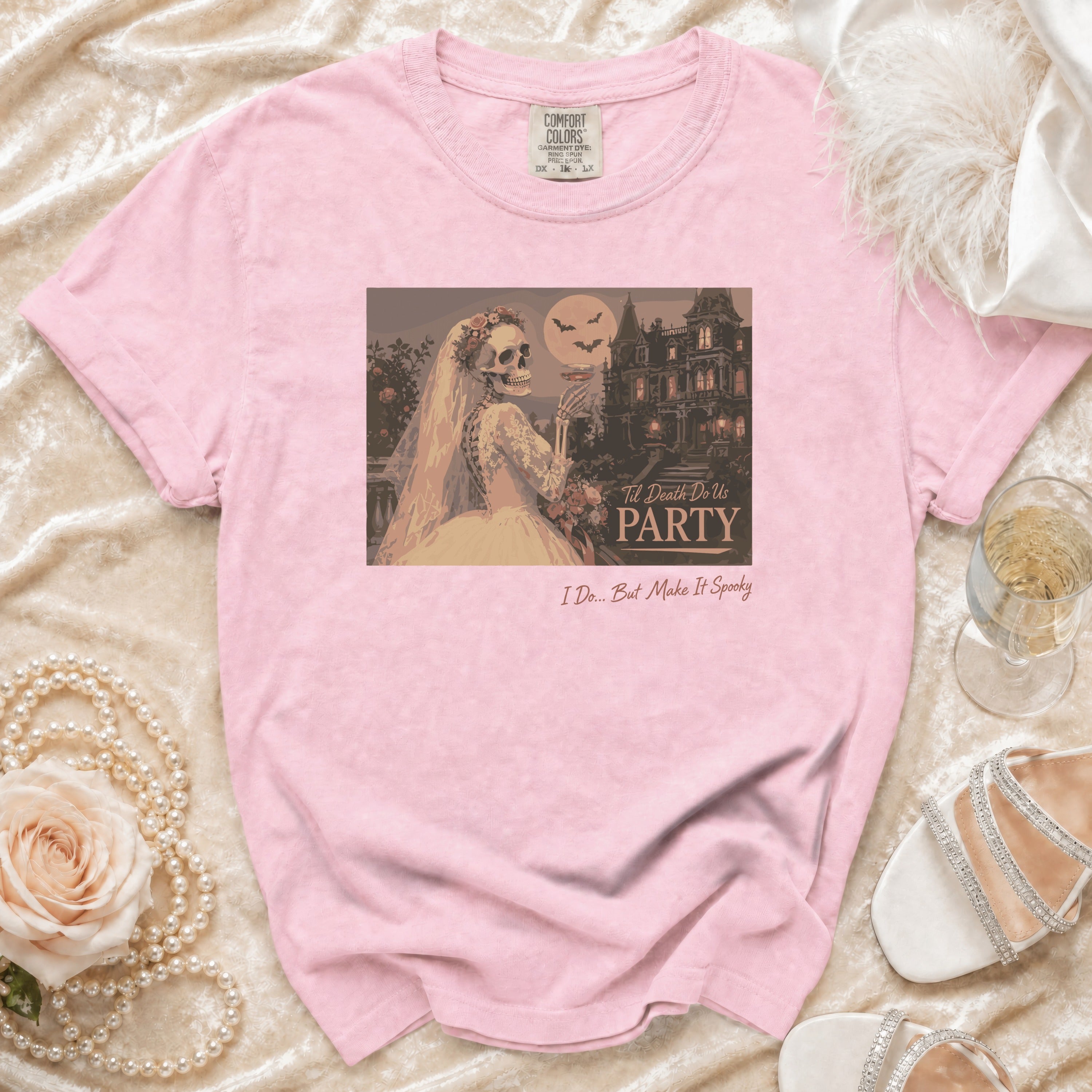 Pink t-shirt with skeleton bride, haunted house, and text: "Til Death Do Us PARTY" and "I Do... But Make It Spooky".