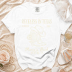 White t-shirt with "Reckless in Texas" and cowboy boot graphic.