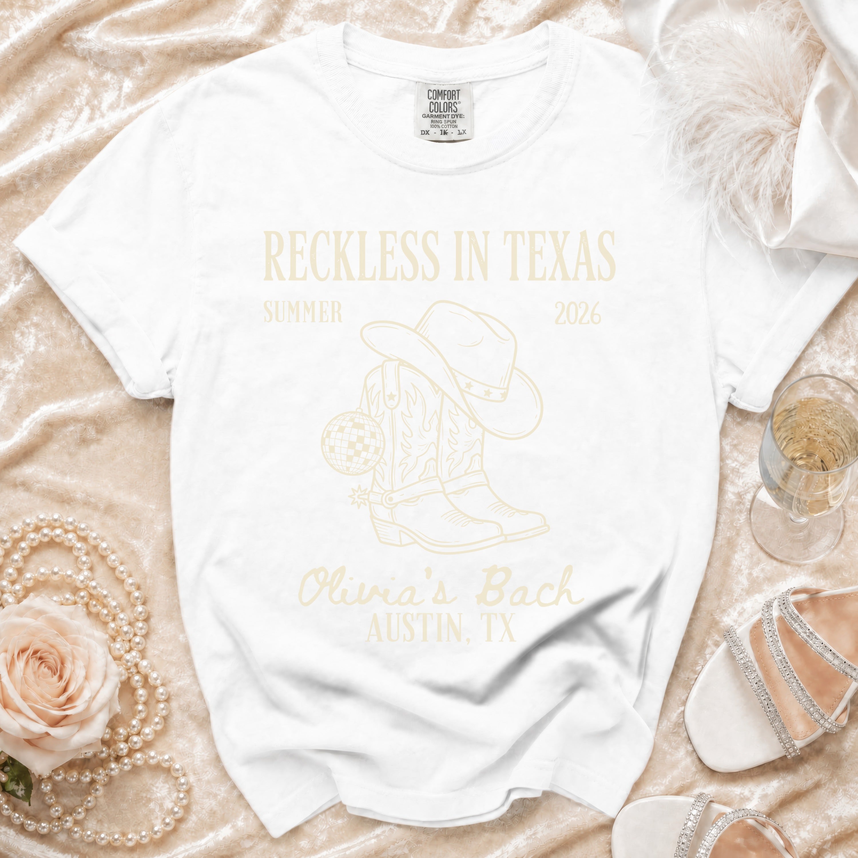 White t-shirt with "Reckless in Texas" and cowboy boot graphic.