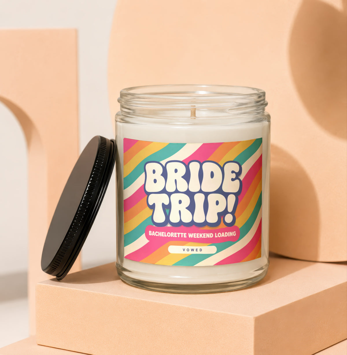 Candle with "BRIDE TRIP! BACHELORETTE WEEKEND LOADING VOWED" on label.