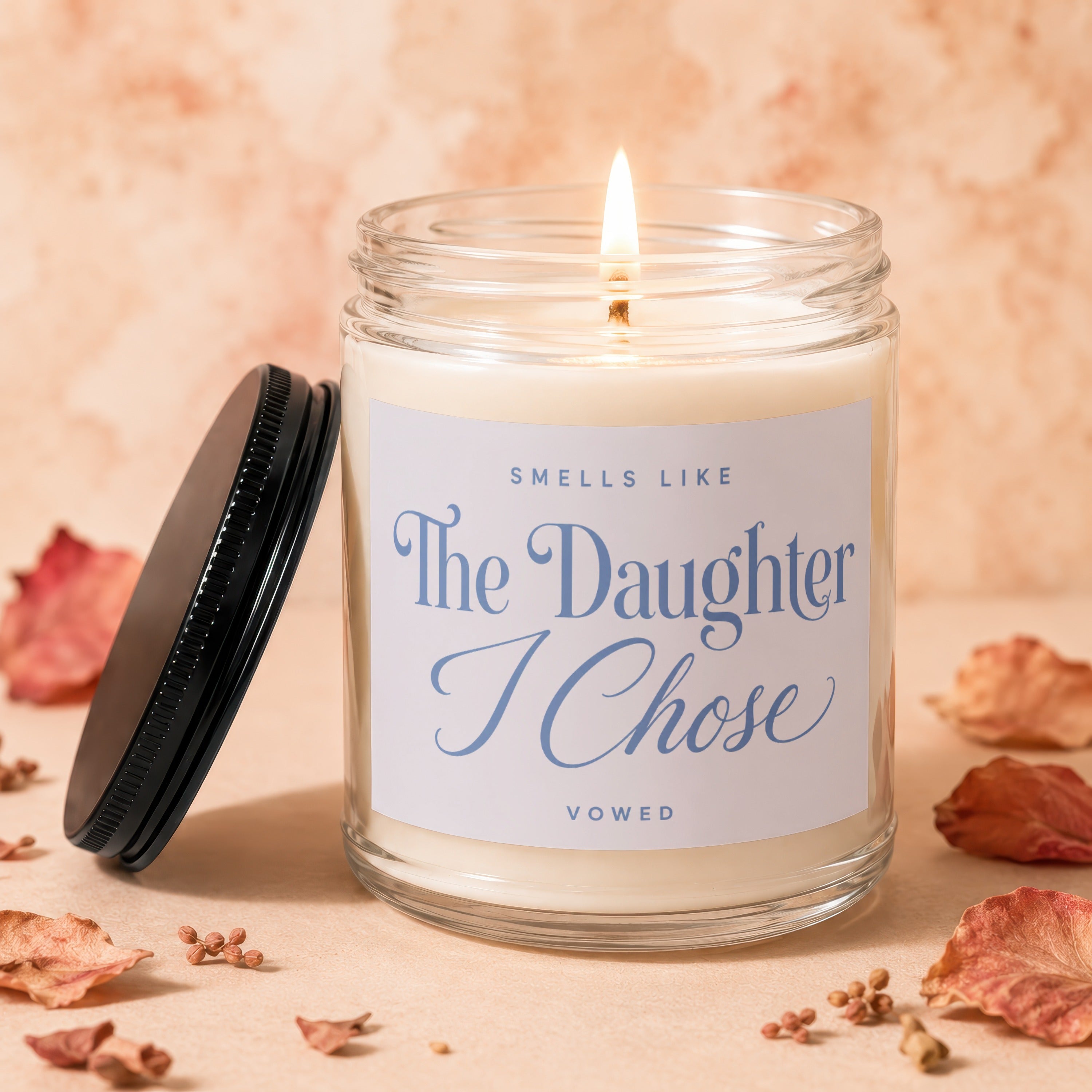 Burning glass candle with label reading "SMELLS LIKE The Daughter I Chose"