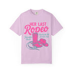 Pink t-shirt with "Her Last Rodeo" text, cowboy boot, hat, and lasso.