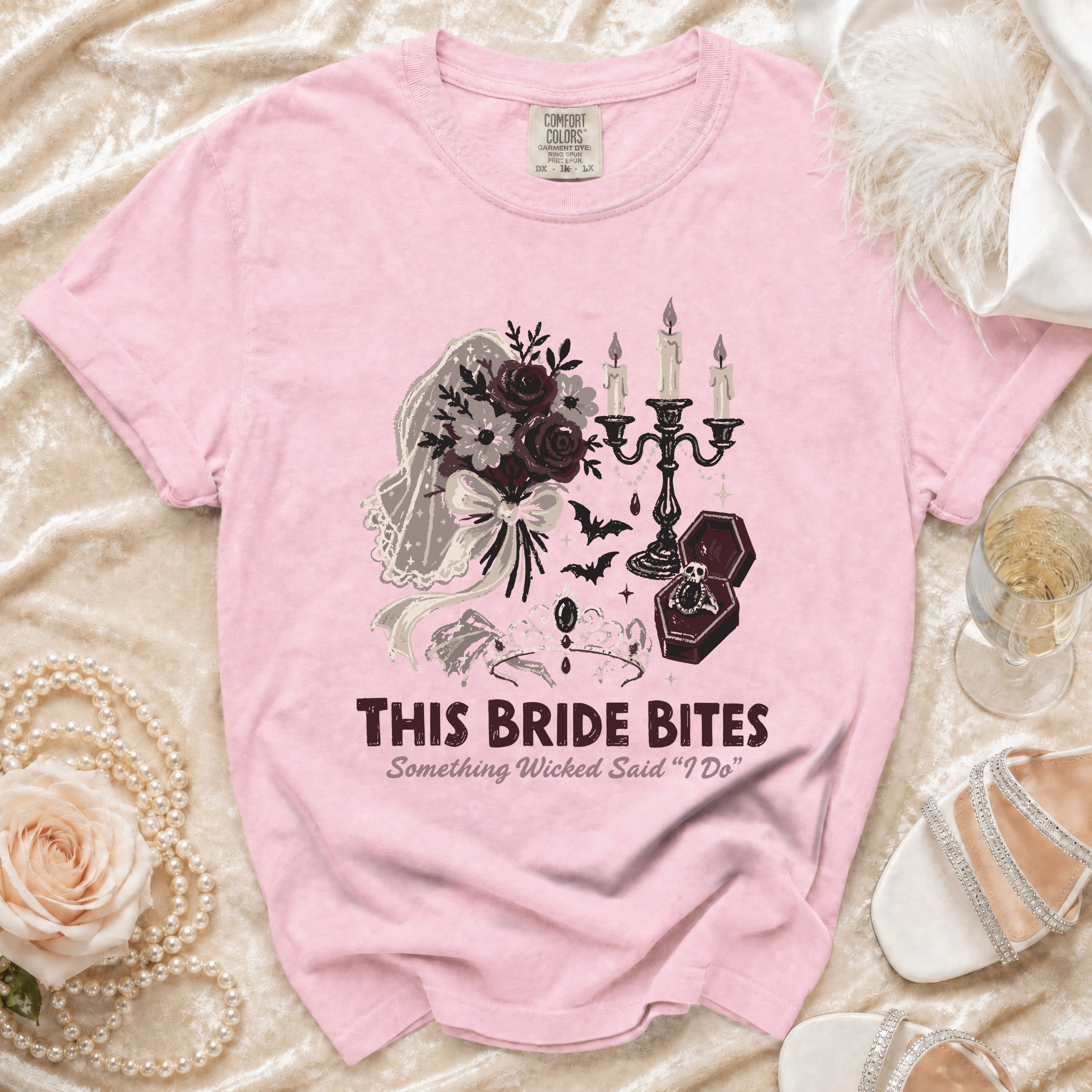Pink t-shirt with graphic text "THIS BRIDE BITES" and wedding/gothic imagery.