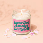 Lit candle with pink label that reads "Forever Starts Someday Every Day VOWED".