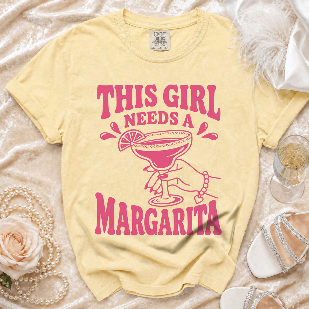 Yellow t-shirt with pink text "This Girl Needs A Margarita" and graphic.