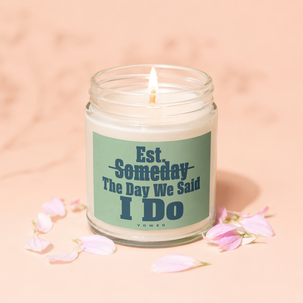 Candle with text "Est. Someday The Day We Said I DO" surrounded by pink petals.