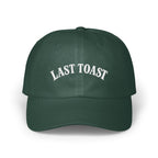 Green baseball cap with white embroidered text "LAST TOAST".