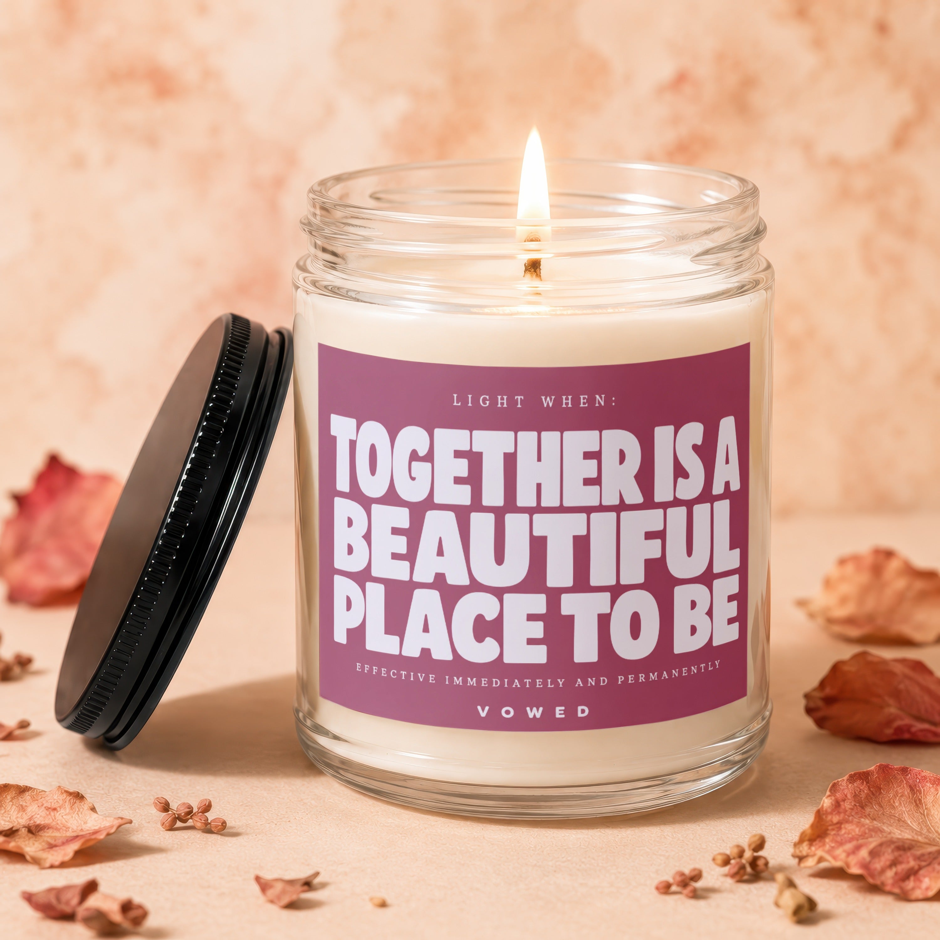 Lit candle with text "Together is a beautiful place to be" on label.