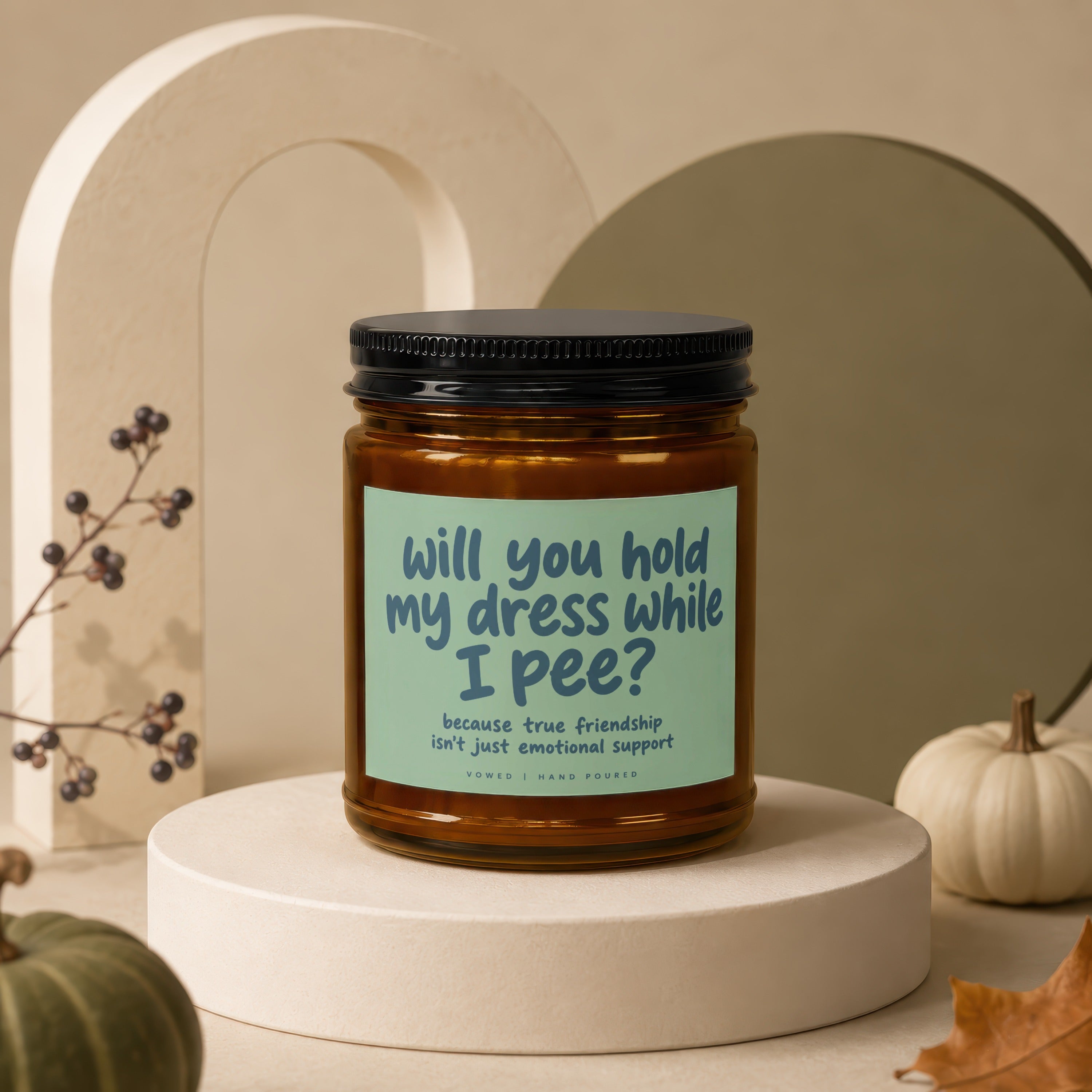 Candle with text "will you hold my dress while I pee?" and "hand poured".