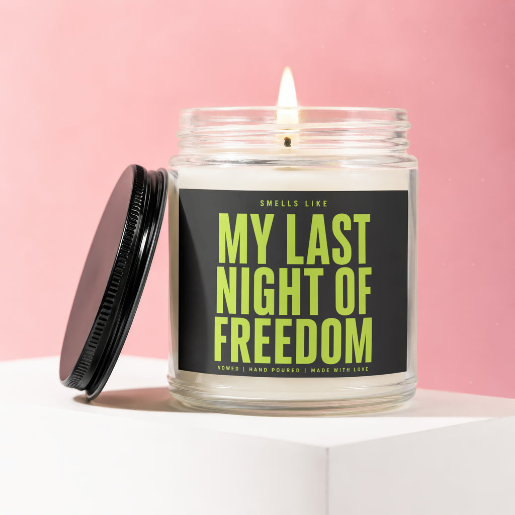 Candle with black lid titled "My Last Night of Freedom" on a pink background.